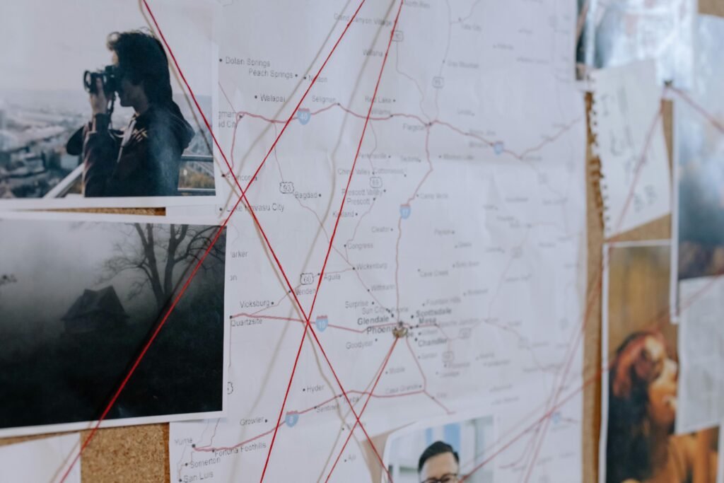 Investigative bulletin board with maps, photos, and red threads connecting clues.